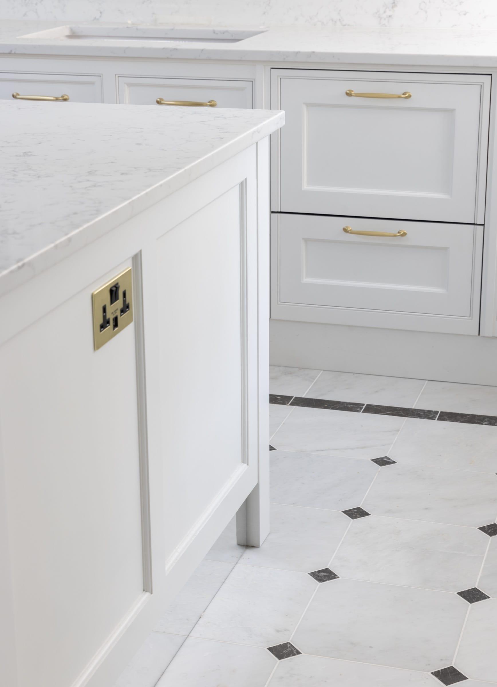 Kitchen island end in painted in-frame joinery over a marble floor with inset dots — Chester Square, Belgravia SW1W