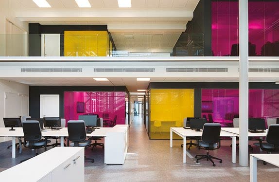 Open-plan office with magenta and yellow glass meeting rooms, Milan