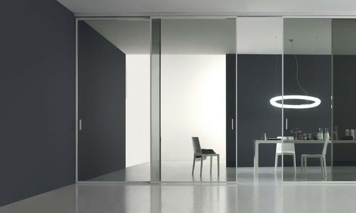 Full-height glazed sliding wall opening onto a white office