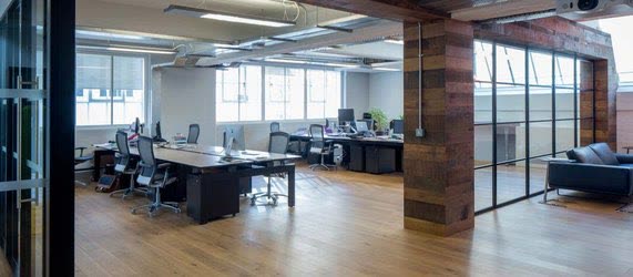 Warehouse-style glazing across an open office with timber beams, London