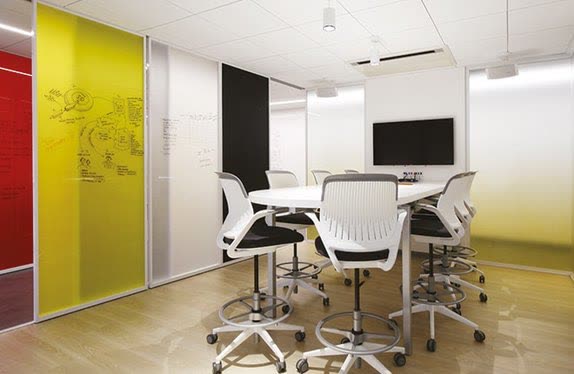 Meeting room behind yellow-tinted glass with white chairs, Rome