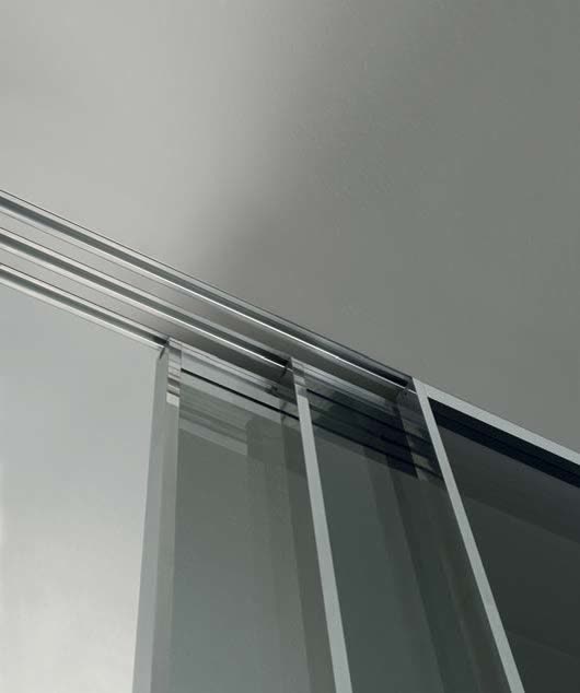 Slim overhead track carrying full-height glazed sliding panels
