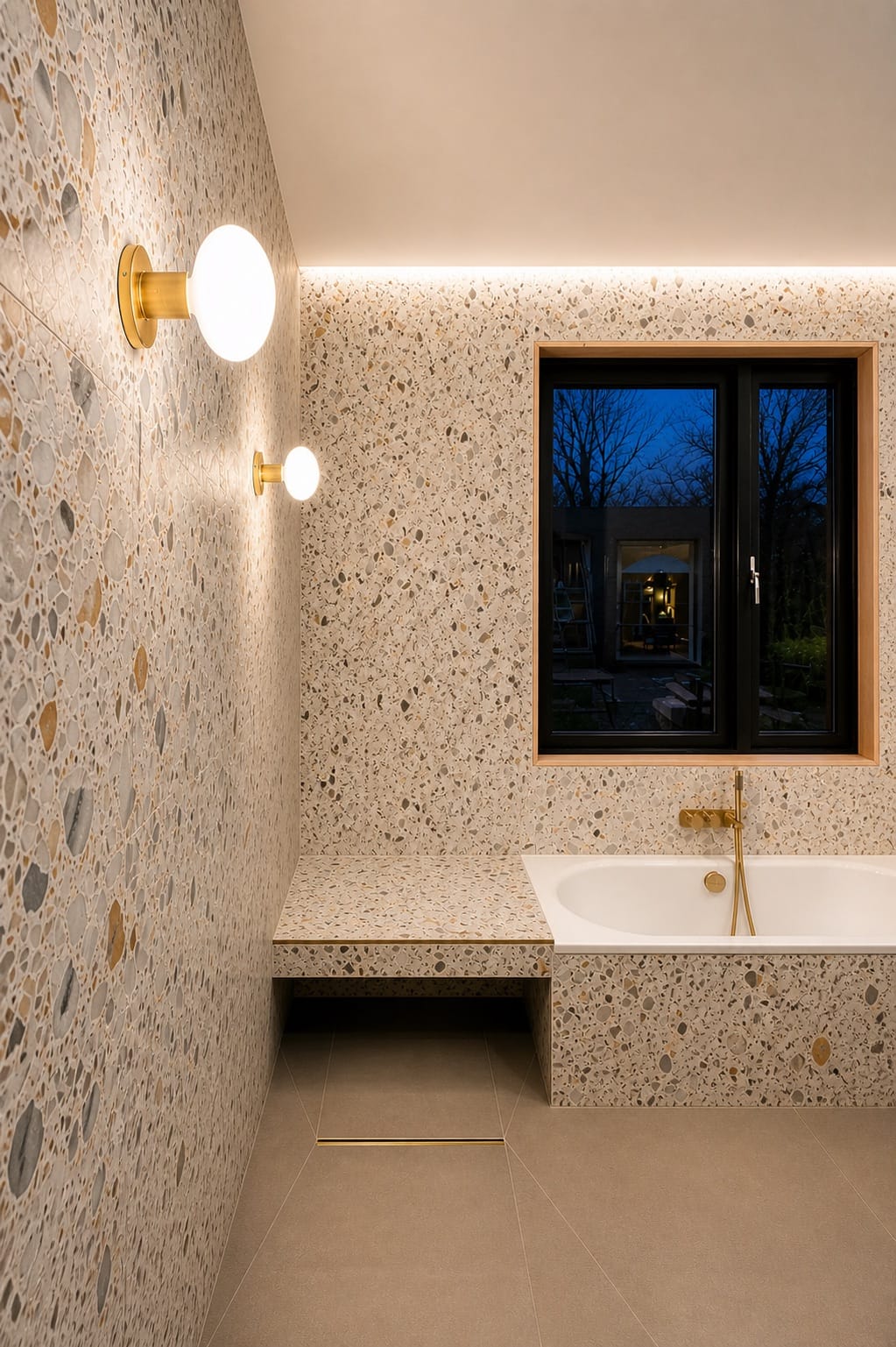 Terrazzo bathroom at night, the bath lit by wall globes beneath the window — Moncrieff Street, Peckham SE15