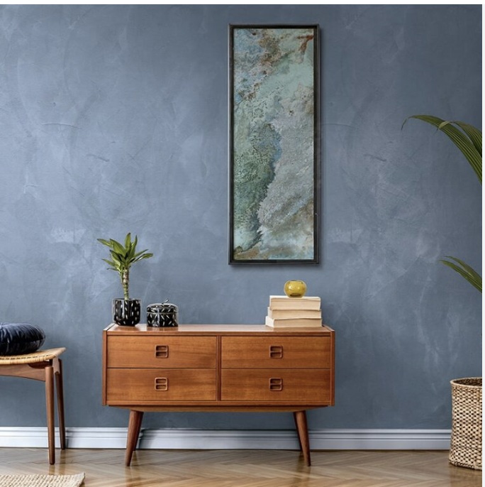 Slate blue matt wall with the trowel figure held back, above a mid-century timber sideboard