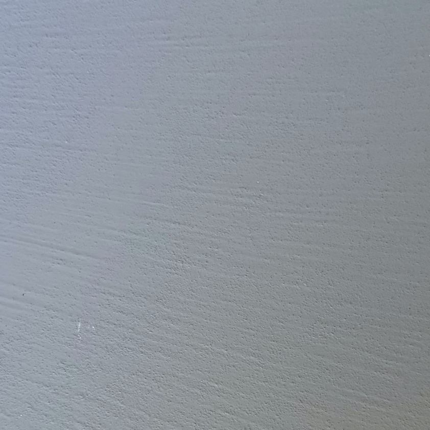Close-up of a grey resin sample board with fine horizontal combed ridges