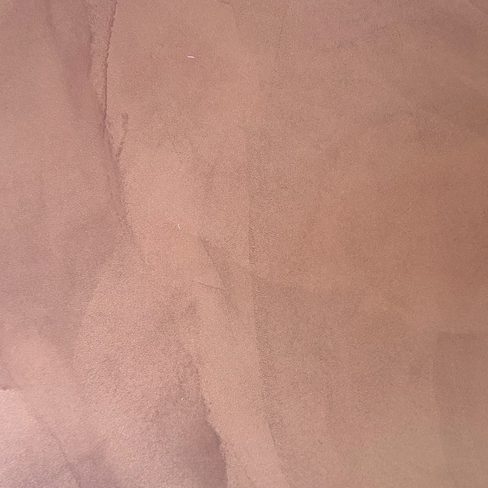 Close-up of a warm terracotta resin sample board with soft cloud-like trowel marks