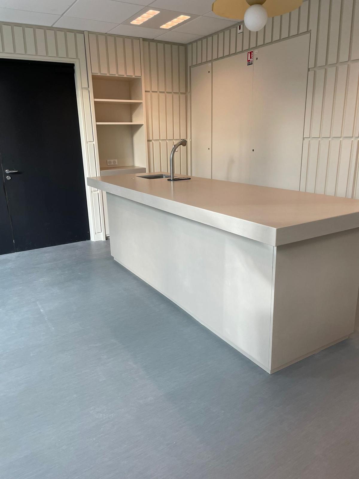 Resin counter with the same seamless finish carried down the front panel and across the floor beneath it