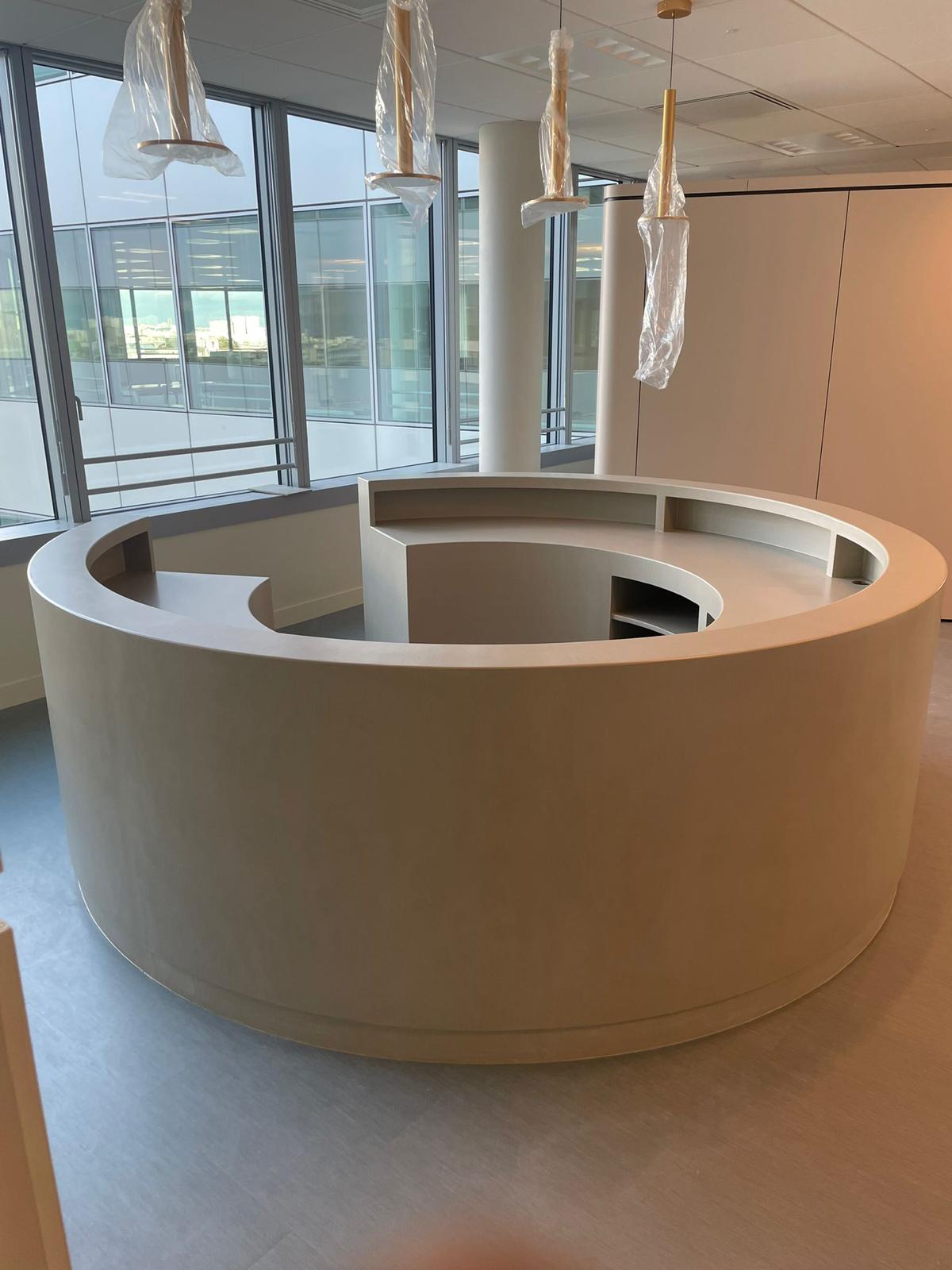 The same circular resin counter from the window side, the curve and the flat top in one unbroken surface